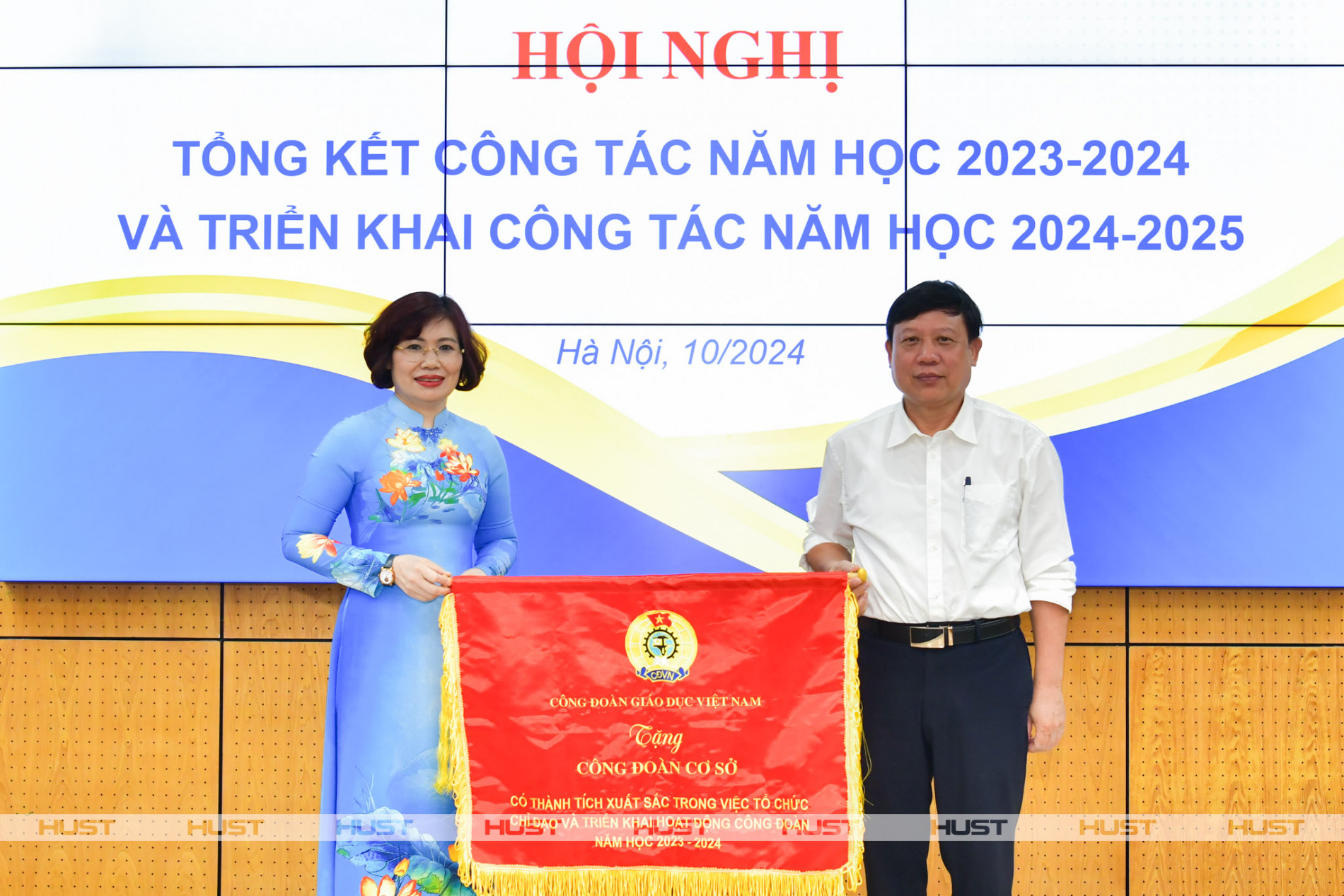 Bà Đặng Hoàng Anh - Phó Chủ tịch Công đoàn Giáo dục Việt Nam - trao cờ thi đua cho PGS. Bùi Đức Hùng – Phó Bí thư Thường trực Đảng ủy, Chủ tịch Công đoàn Đại học Bách khoa Hà Nội